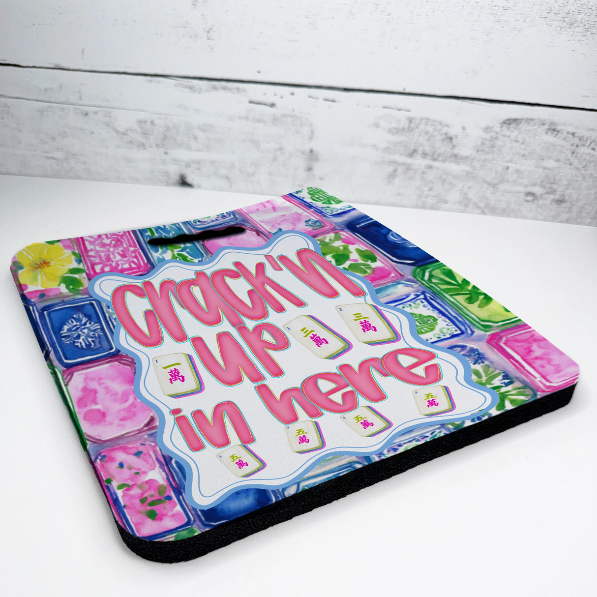Colorful mahjong seat cushion with text 'Crackin' Up in Here' on a white surface.
