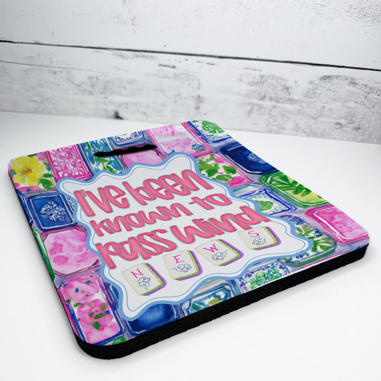 Colorful mahjong seat cushion with text and floral patterns on a white surface