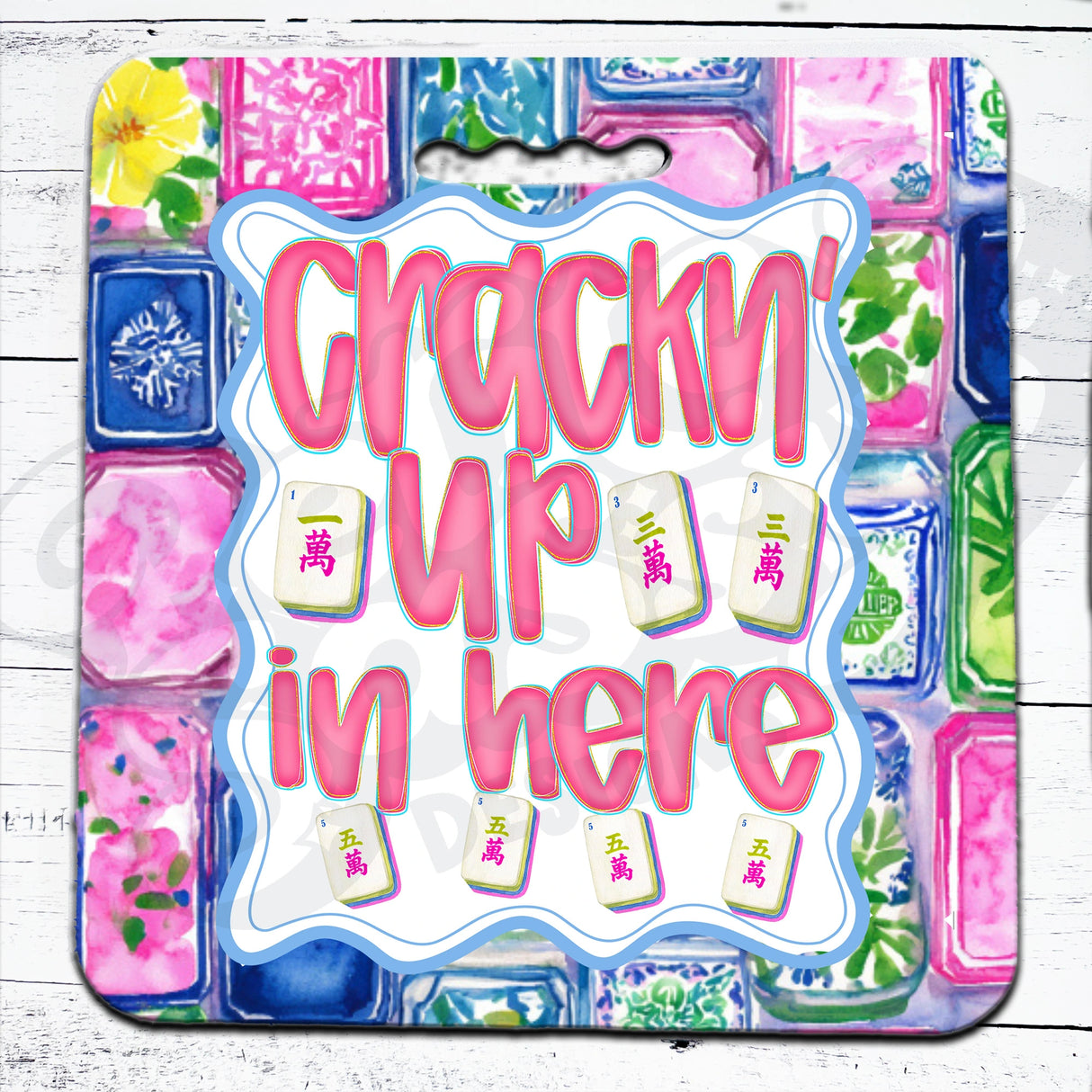Colorful mahjong seat cushion with 'Crackn'' Up in here' text and decorative elements on a white wooden surface.