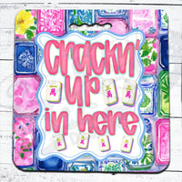 Colorful mahjong seat cushion with 'Crackn'' Up in here' text and decorative elements on a white wooden surface.