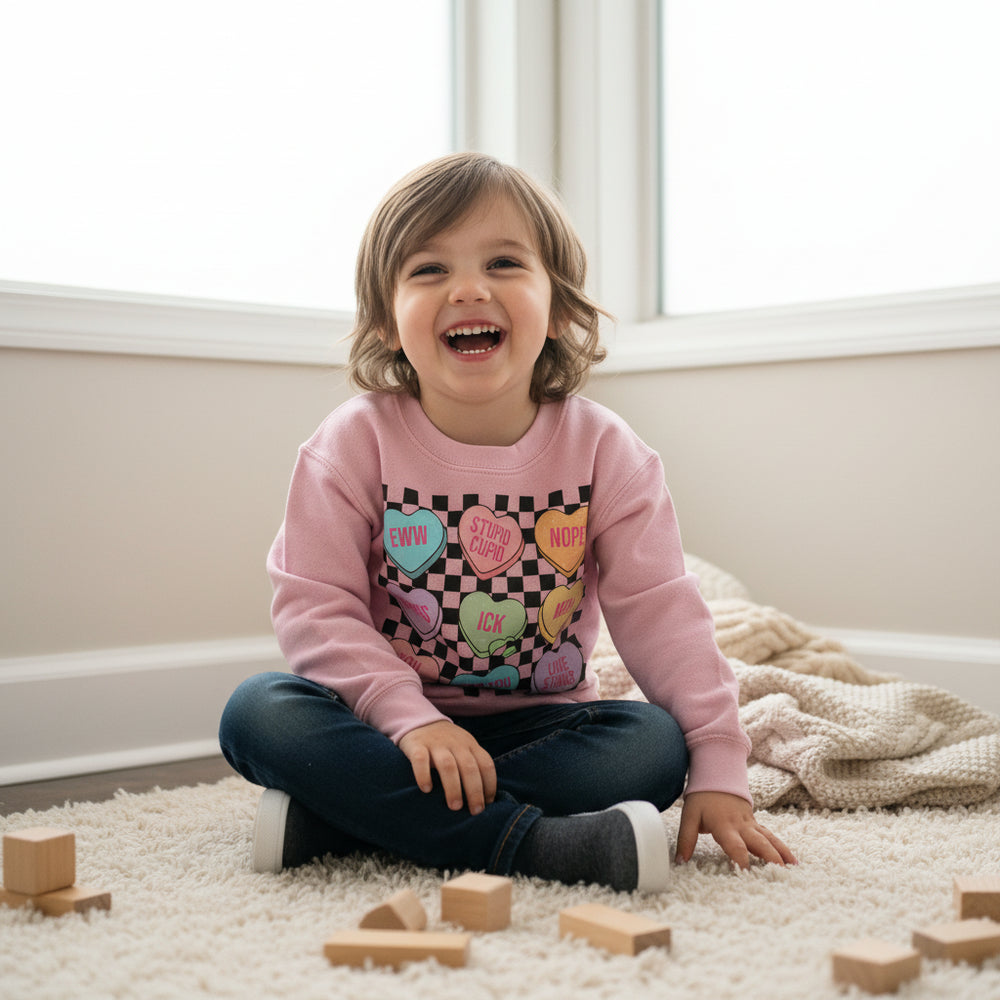 Pink sweatshirt with colorful heart-shaped text on a checkered background
