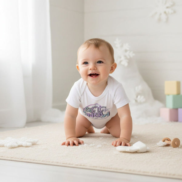 A baby crawling on a cream rug in a bright, white nursery setting, wearing a white short-sleeve bodysuit with a purple and blue monogram graphic on the chest.