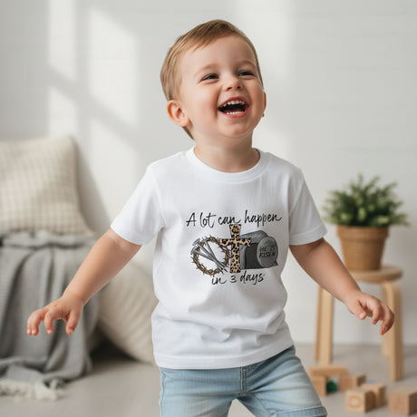 Child wearing a white t-shirt with a graphic design and text, standing in a room with a neutral background.