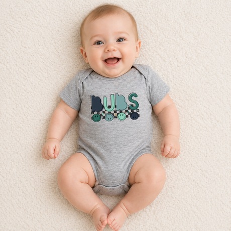 Baby wearing a gray onesie with 'Bubs' print on a beige carpet