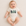Baby wearing a onesie with 'BUBS' printed on it, sitting on a soft surface.