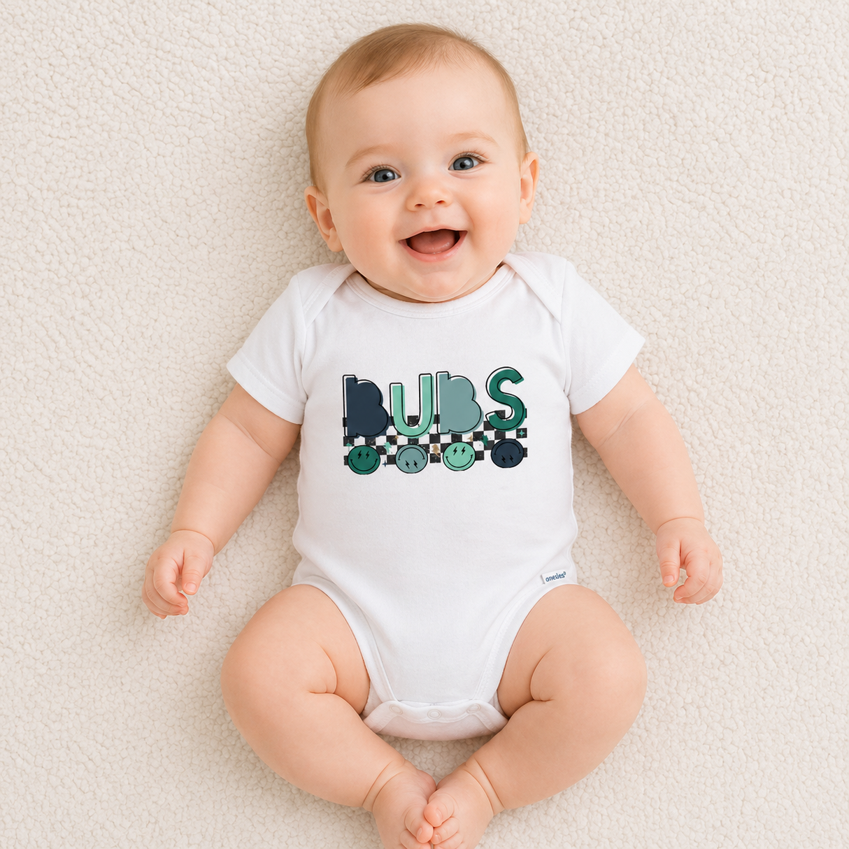 Baby wearing a white onesie with 'BUBS' print on a light background