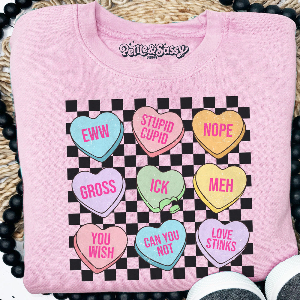 Pink sweatshirt with colorful heart-shaped text on a checkered background