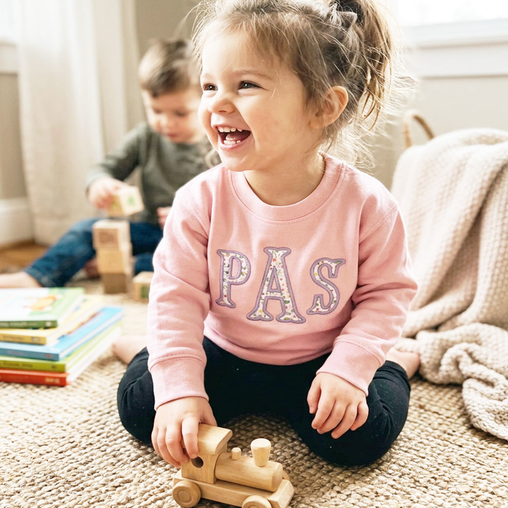 Monogram with floral fabric embroidered on pink sweatshirt