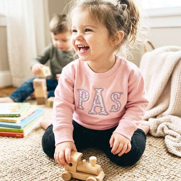 Monogram with floral fabric embroidered on pink sweatshirt